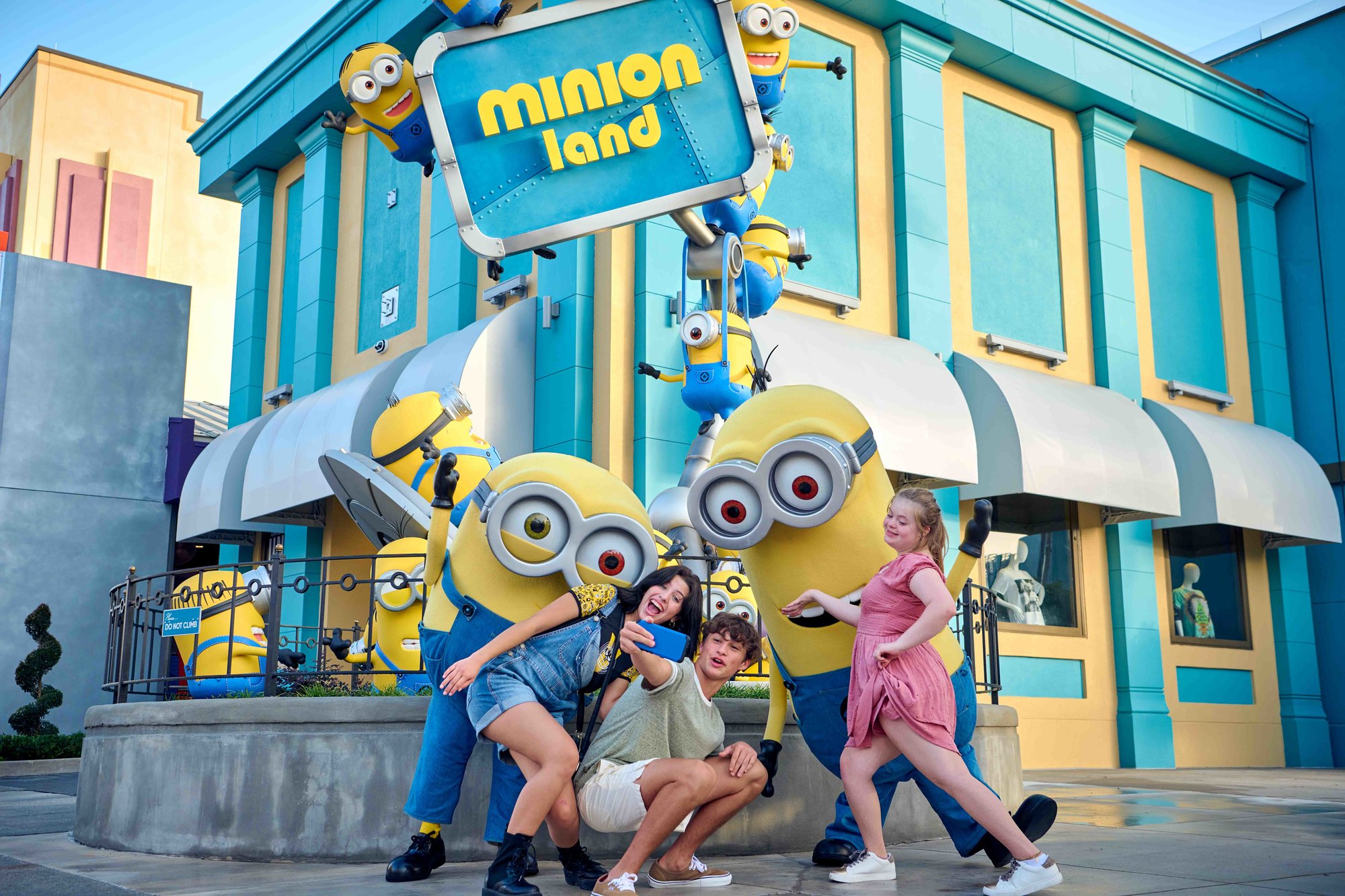 minion land marquee with three people in front